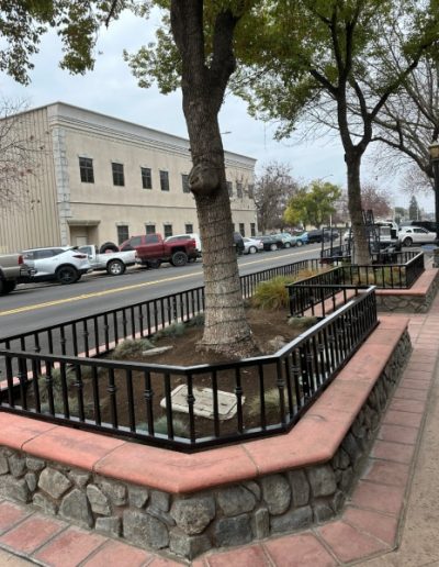View of a black chain-link fence surrounding a construction site with a building under construction