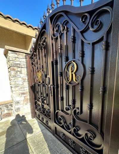 Driveway gate with a classic design, featuring black metal construction and decorative accents