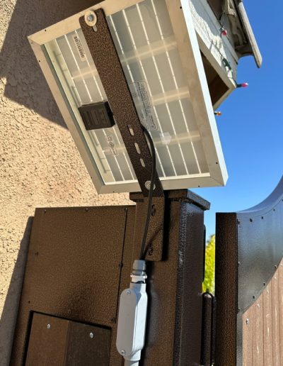 View of a black double gate with an automatic opener, showcasing the gate in an open position