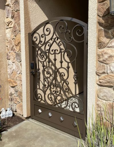 Custom-made black metal gate with intricate patterns, adding value and curb appeal to the home