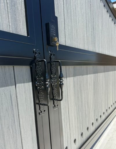Black metal driveway gate with an arched top, creating a welcoming entrance to the property