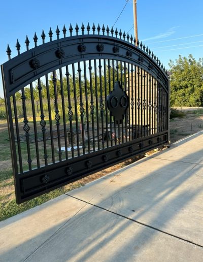 Black metal double gate with an automatic opener and an elegant design, creating a welcoming entrance