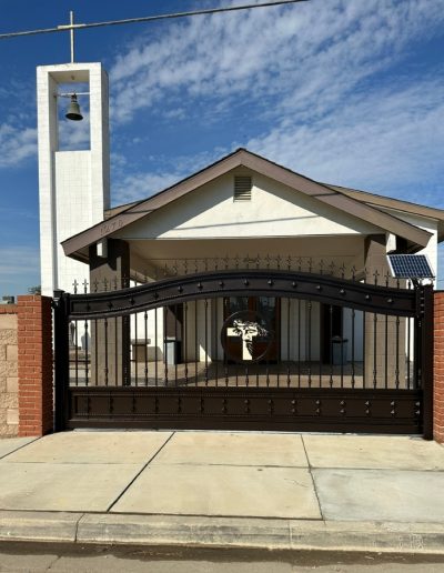 Black metal double gate with an automatic opener, providing a secure and stylish entrance with the convenience of remote operation