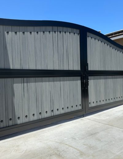 Custom-made metal gate with a decorative wood-grain finish for enhanced home security