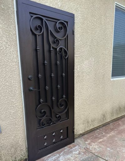 Decorative metal security door with a monogram, adding curb appeal and style to the entrance