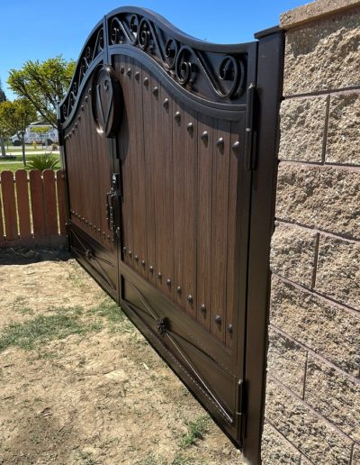 Decorative metal gate with a wood-grain finish, providing privacy and security for the property
