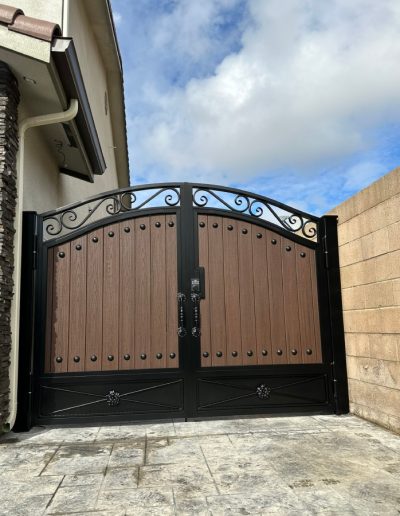 Metal gate with an arched top and decorative hardware, creating a welcoming entrance