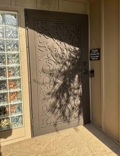 High-quality metal security door with a monogram and a decorative cut-out pattern