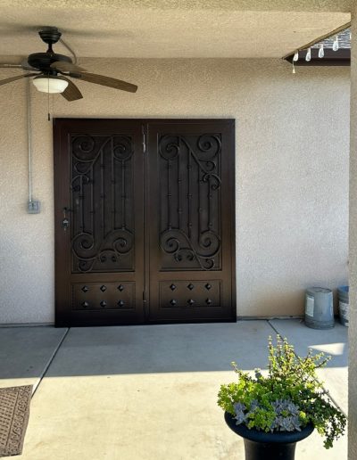 Durable metal security door with a monogram and a decorative design, offering both style and protection