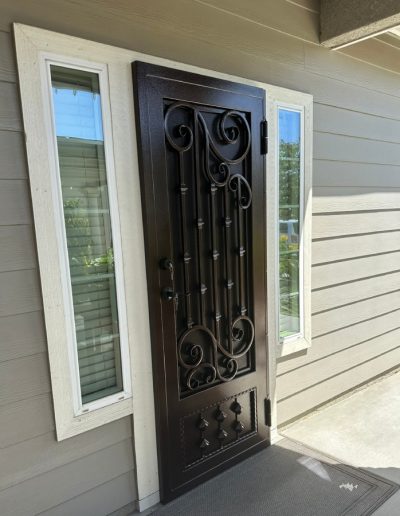Custom-made metal security door with a monogram, adding value and curb appeal to the home