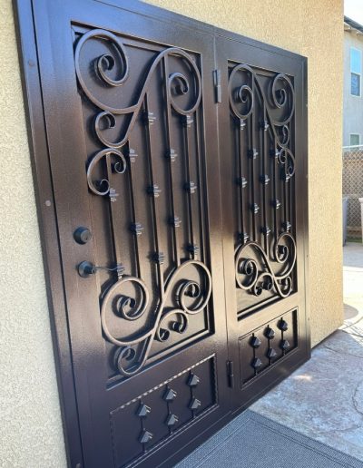 Metal security door with a monogram and a decorative cut-out, providing security and style for the entrance