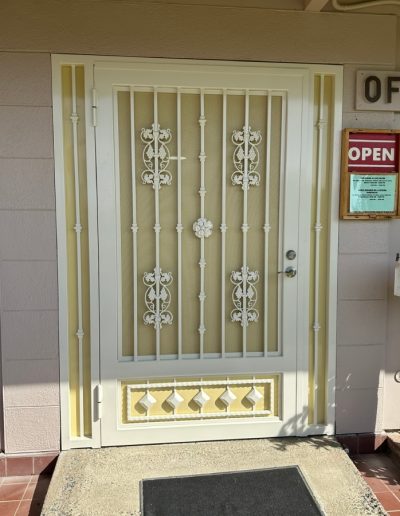 Decorative metal security door with a monogram, enhancing the privacy and security of the home while adding a touch of elegance