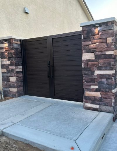 Metal gate with an arched top and decorative hardware, providing a secure and stylish entrance