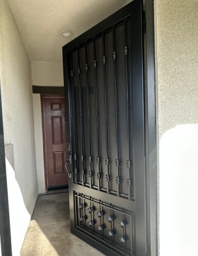 Close-up of a wrought iron gate with intricate details and decorative flourishes