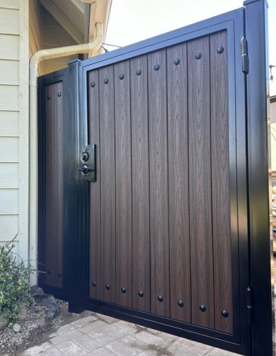 Black metal double gate with decorative accents, providing secure access to a driveway