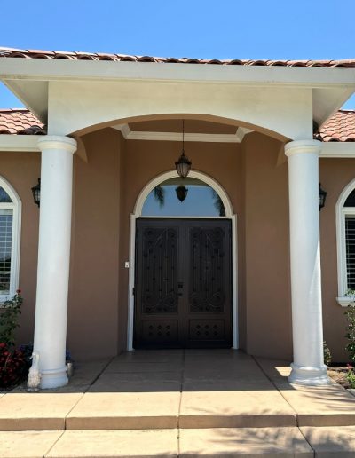 Custom-made wrought iron gate with decorative scrolls and an arched top for enhanced home security