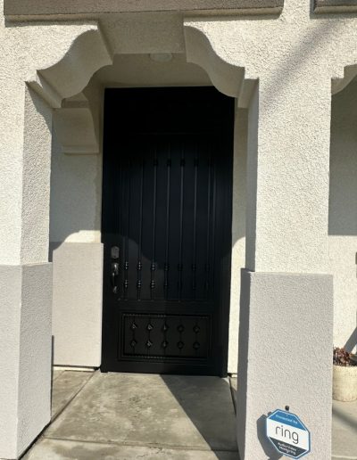 Decorative wrought iron gate with an arched top, providing privacy and security for the property