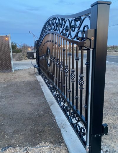 Black metal double gate with an elegant design, creating a welcoming and inviting entrance
