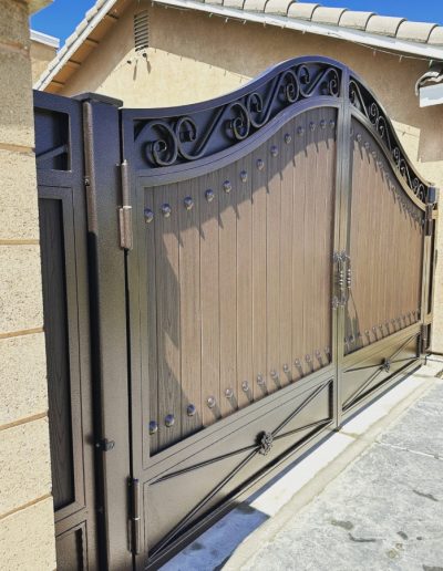 Decorative black metal double gate, providing privacy and security for the property