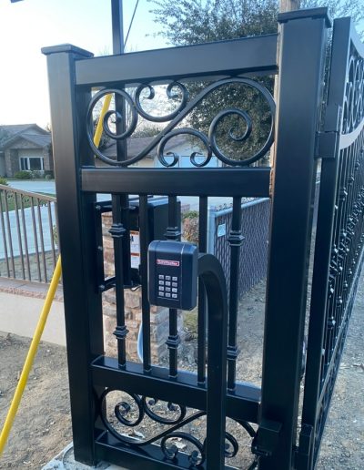Custom-made black metal double gate with decorative accents, adding value and curb appeal to the home