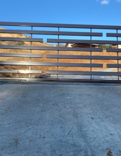 Elegant black metal driveway gate with vertical bars and a classic design