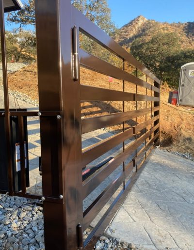 Custom-made black metal gate with an arched top and decorative finials
