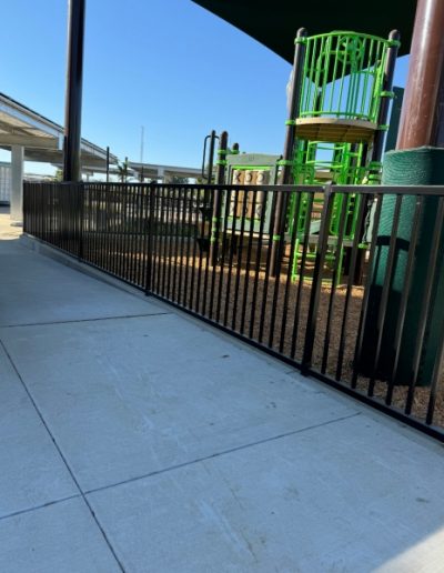 Metal dog run with a black fence and gate, providing a safe and secure space for pets