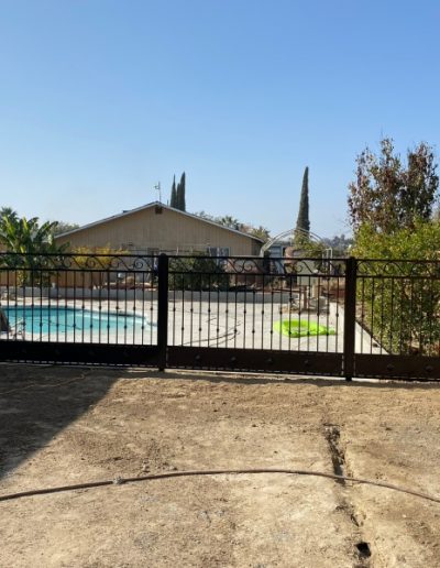 Custom-made metal fence with a decorative gate, showcasing skilled craftsmanship and attention to detail